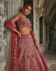 Dusk in Blossom Lehenga Set - Woman in a traditional pink and gold embroidered lehenga