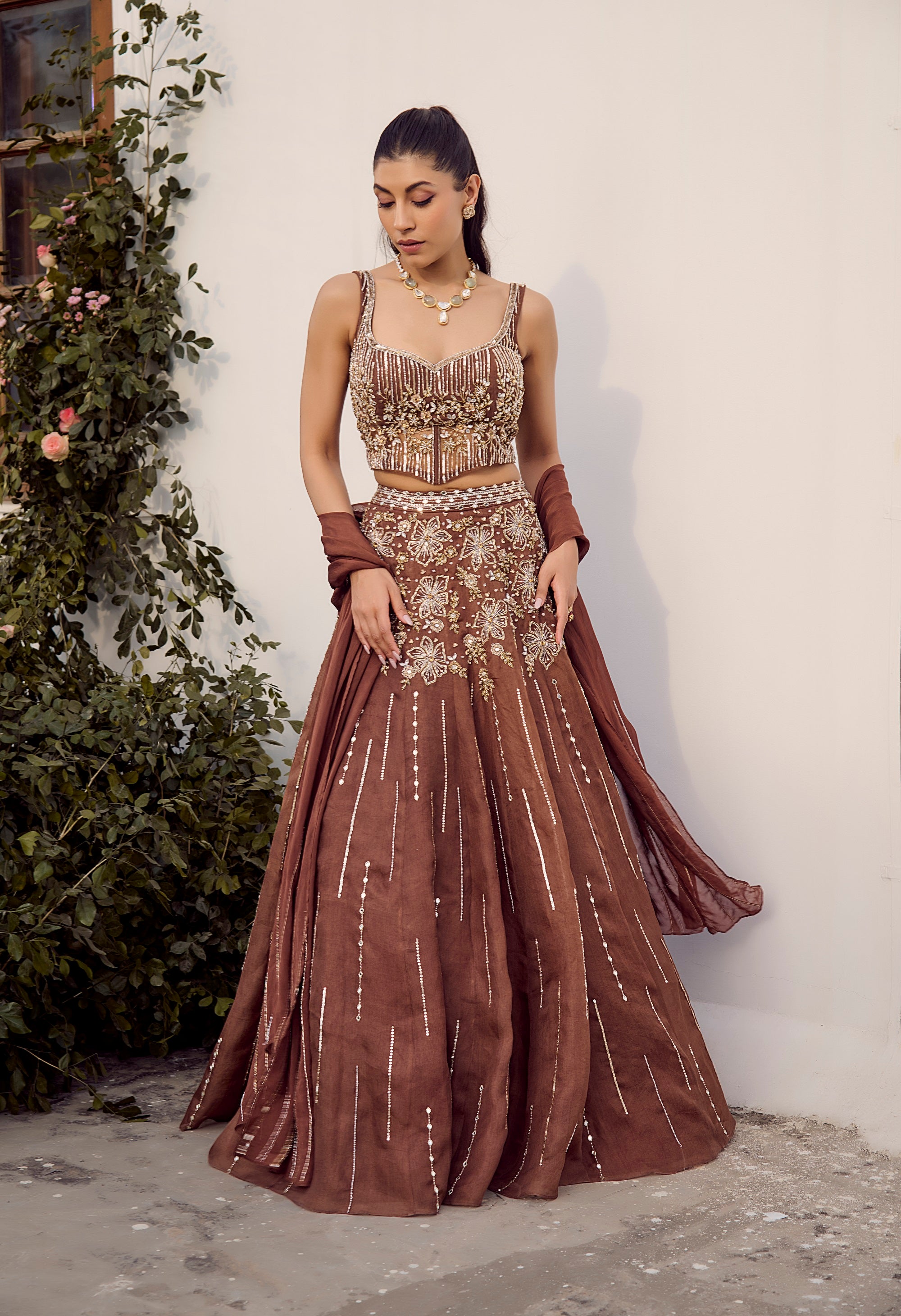 Dust Allure Lehenga Set. Woman wearing a brown embroidered traditional lehenga