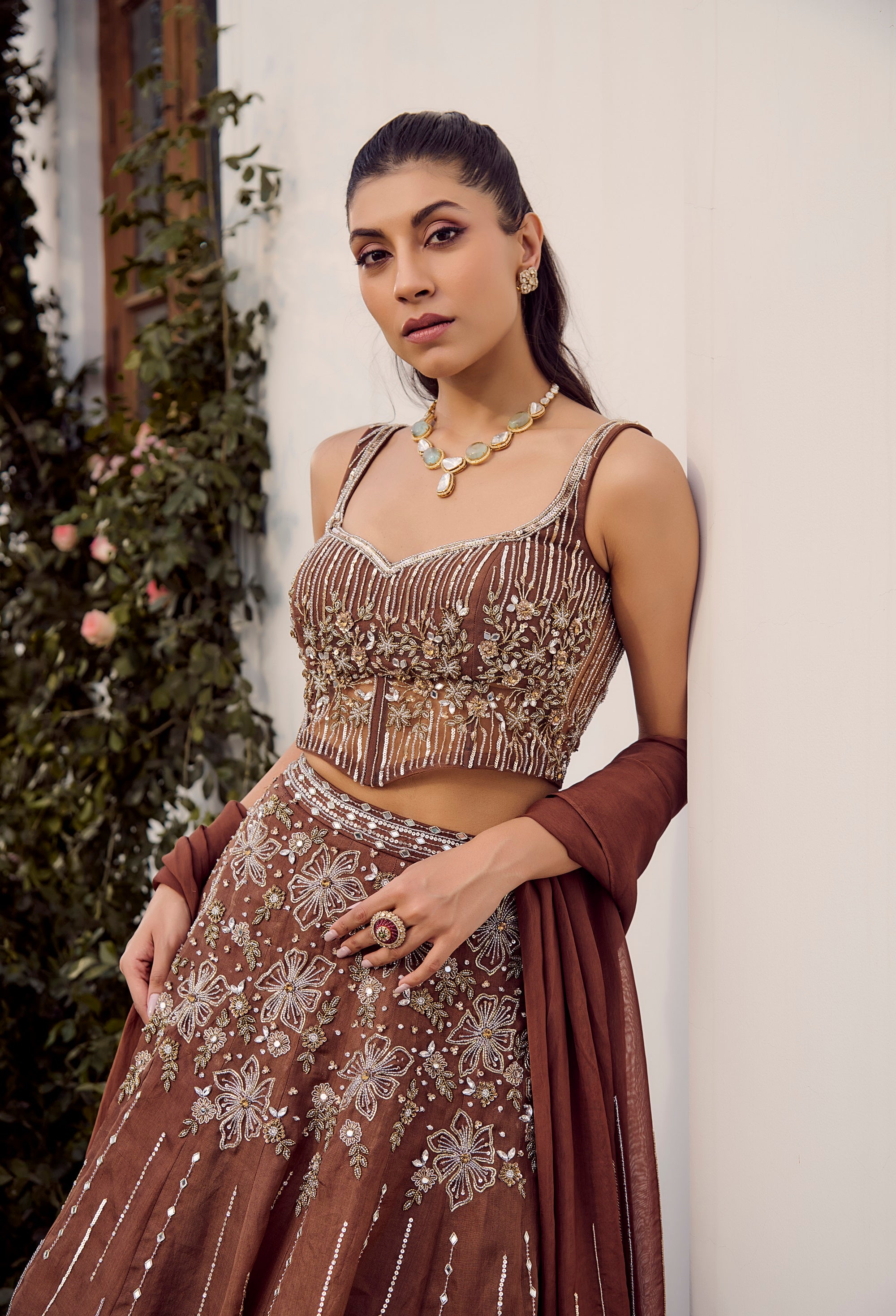 Dust Allure Lehenga Set. Woman in traditional brown outfit with intricate patterns.