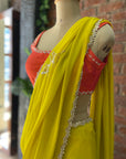 Mustard Georgette Embroidered Saree. Mannequin wearing a bright yellow saree with a red blouse